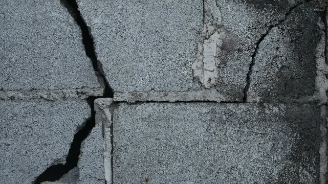 Weathered Grey Concrete Block Wall Large Diagonal Crack Close Up Urban Decay Structural Damage Grunge Texture Background Portrait
