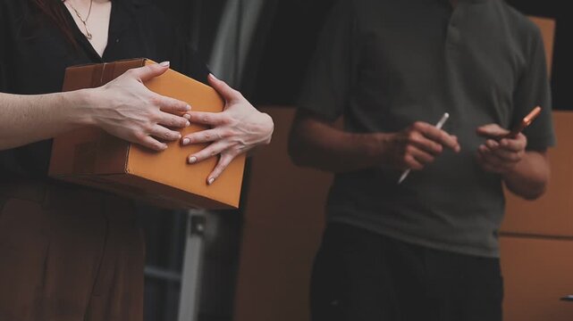 Woman giving parcel to man in delivery office