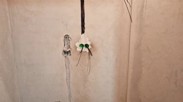 Electrical wiring and double electrical outlet boxes installed in an unfinished interior wall during home renovation. Construction progress before plastering, painting, and final electrical finishing