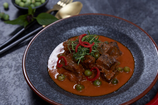 Thai cuisine, homemade beef curry Panang on black background.