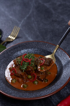Thai cuisine, homemade beef curry Panang on black background.