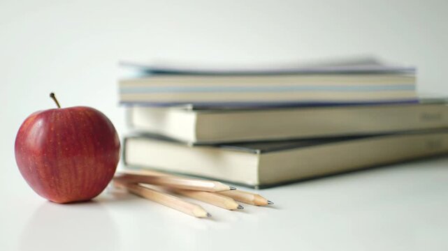Blank spiral notebooks with wooden pencils ruler and paperclips on a white background under sunlight