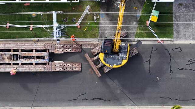 Aerial Top Down View of Excavator Loading onto Transport Trailer
