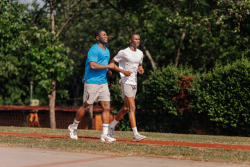 Fototapeta premium Two young men enjoying outdoor jogging on track