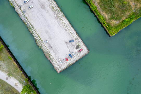 Aerial view of industrial pier with parking lot and cars