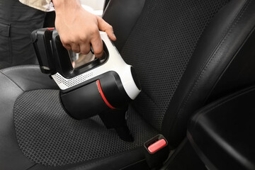Handheld vacuum cleaning car seat upholstery © Pixel-Shot