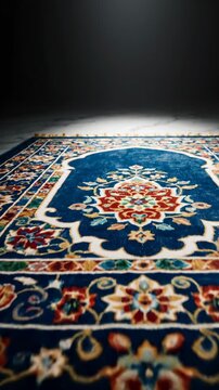 Ornate Persian rug with intricate blue floral pattern and gold tassels, displayed on marbled floor with dramatic lighting