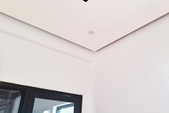 Minimalist drop ceiling made of gypsum board with elegant black line accents in a room with glass windows