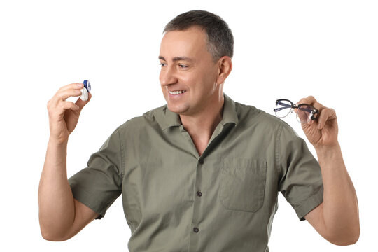 Mature man with contact lens case and eyeglasses on white background