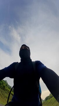 Man Cycling Under Cloudy Sky