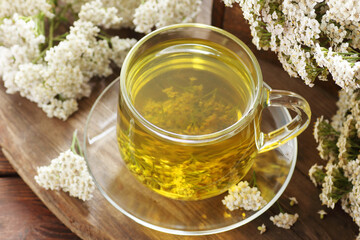 Herbal yarrow tea in glass cup with fresh achillea flowers on rustic wooden background with copy space © spiegelka