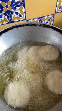 Slow motion of deep frying a snack made with whole wheat flour called mathri or matthi in oil