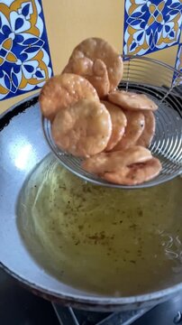 Slow motion of deep frying a snack made with whole wheat flour called mathri or matthi in oil