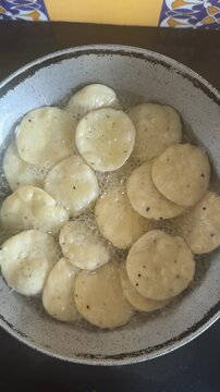 Deep frying a snack made with whole wheat flour called mathri or matthi in oil