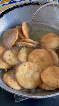 Deep frying a snack made with whole wheat flour called mathri or matthi in oil