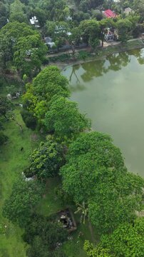 Aerial view of a tranquil lake bordered by lush green trees and a small village showcasing rural