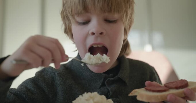 Kid Boy Eat Rice and Sausage. Eating Breakfast Lunch in Kitchen. 4K 10-bit
