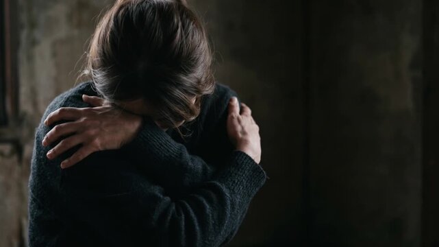 孤独と静寂、自身を抱きしめ耐える女性のシルエット