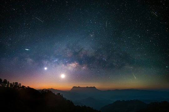 Starry night over mountain long exposure of milky way and  stars in dark night sky.