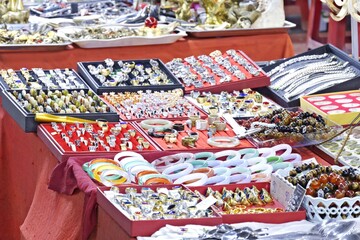 Vibrant jewelry stall featuring jade bangles, gemstones, and rings at a Vinh Long marketplace fair © ProArt Studios
