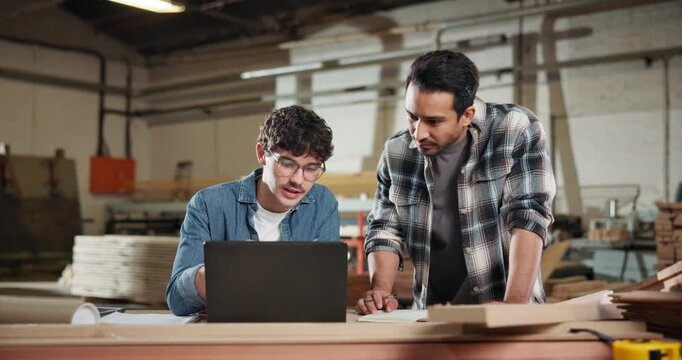 Carpenter, team and laptop in workshop for planning, project management and help for apprentice. Men, tech and discussion in woodworking factory for learning, collaboration and tips for productivity