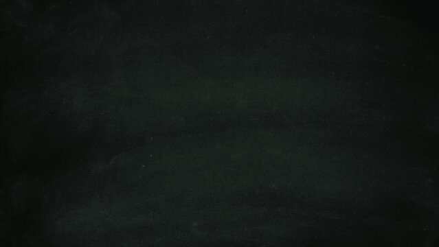 A dark, empty chalkboard with visible dust and smudges, creating a textured background for educational or creative designs.