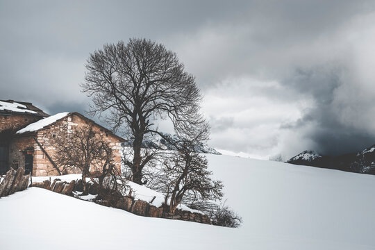 old house in the mountains of lessinia on a dark snowy day