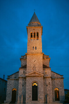 The historic Church of the Ascension of the Lord glows beautifully against the evening sky, showcasing timeless Dalmatian architecture and Mediterranean charm. A scenic landmark perfect for travel.