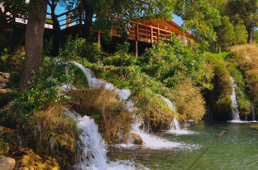 Iconic Berberov Buk waterfall flows through the scenic Zrmanja River landscape near Muškovci, Croatia, surrounded by lush Mediterranean nature. A dramatic travel destination for nature tourism. © Den
