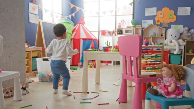 Boy playing with abacus and doll, reaching toward colorful tent and scattered blocks in a bright playroom building; joyful curiosity.