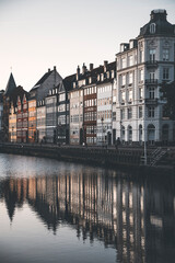 Fototapeta premium detailed view of nyhavn canal at dusk with reflections of the buildings and the boats in the water
