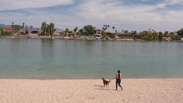 Woman With Dog on Leash Walking on Sandy Beach, Big Bend of Colorado River, Laughlin Nevada USA