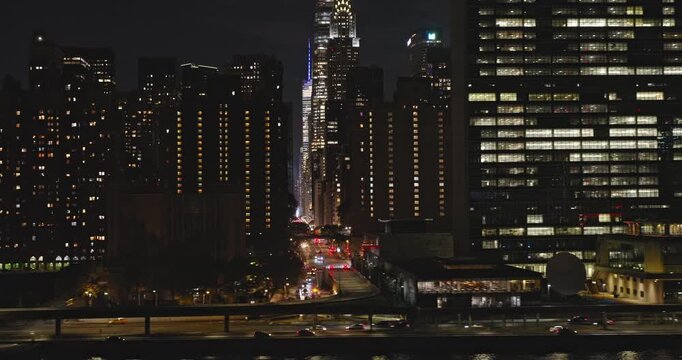 NYC New York Aerial v169 establishing low tracking flyover along East river capturing illuminated skyscrapers cityscape of Midtown East Manhattan at night - Shot with Inspire 3 8k - September 2023