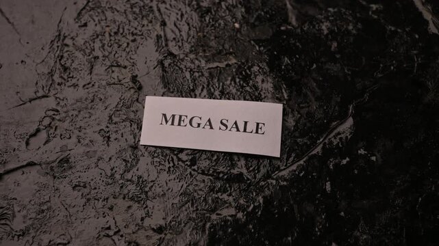 Mega Sale Promotion Card Placed by Hand on Rough Stone Texture Background