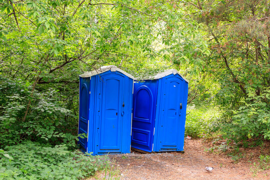 blue plastic toilet boothes in a forest