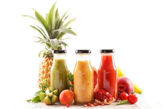 Assortment of fresh fruit smoothies and juices in glass bottles on white background