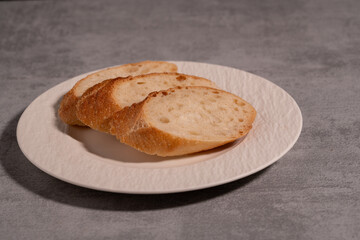 Naklejka premium Rustic Sliced Artisan Bread with Olive Oil on White Plate, Cozy Food Photography