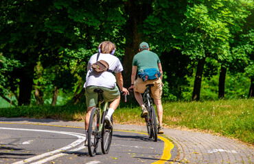 Obraz premium Cyclists ride on the bike path in the city Park 