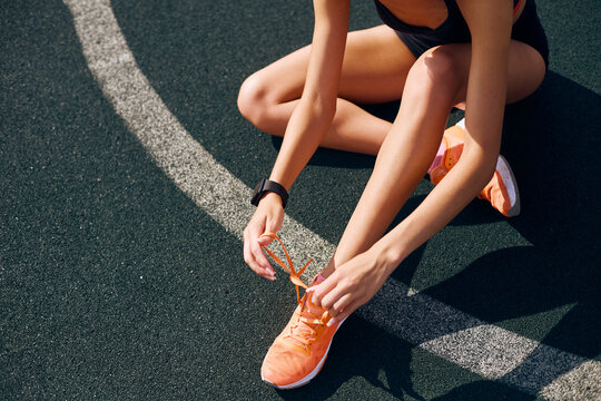 Fit woman tying up laces on her sport shoes