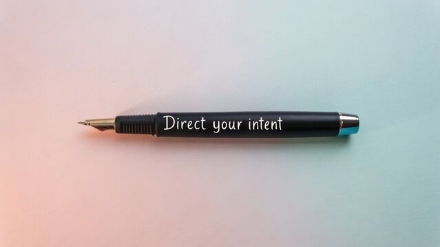Black fountain pen resting on a pastel background with the phrase "Direct your intent" in elegant script font