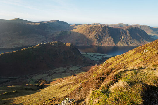 Views down towards Low Bank and Rannerdale from Whiteless Pike with the summit of Mellbreak in the distance in the Lake District, Cumbria, England UK.