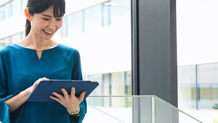 オフィスでタブレットを使う女性 © metamorworks