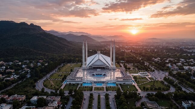 The majestic Faisal Mosque sits beautifully at the foot of the green Margalla Hills as the morning sun rises over the horizon.
