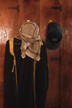 Traditional Arab thobe and keffiyeh hanging on wooden wardrobe