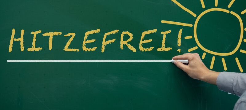 Hitzewelle - Hitzefrei an deutscher Schule - Lehrer schreibt deutschen Text mit Kreide an gr&uuml;ne Schultafel