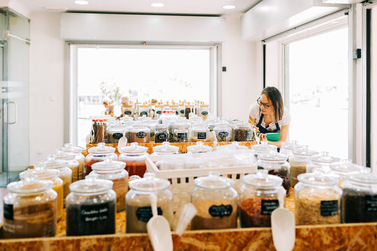 Entrepreneur working on laptop in zero waste bulk spice shop
