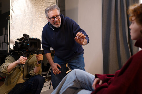 A film director instructs an actress while a cameraman films her