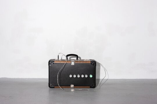 Vintage suitcase with electronic buttons and wire indoors