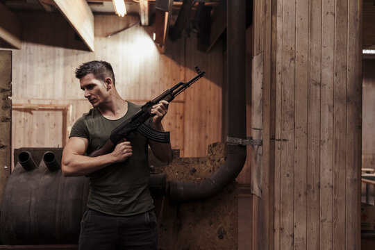 Man holding a rifle in an indoor shooting range