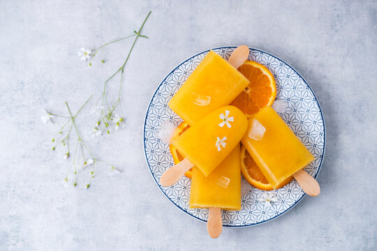Dish with homemade orange popsicles